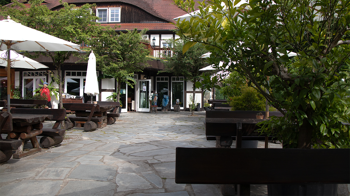 Außenbereich der Boltenmühle bei 53.0372067, 12.8039617 mit Terrasse, Sitzplätzen, Sonnenschirmen und historischem Restaurantgebäude.